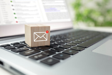 New email symbol on wooden block on laptop keyboard