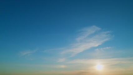 Sunset sky. Orange blue sunset sky clouds. Jet contrail as airplane streaks across the sky with...