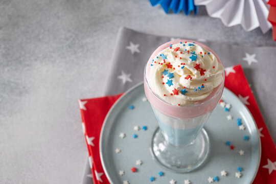 Patriotic homemade milkshake on gray background. Food and dessert for Independence Day in red, white and blue colors. Copy space. Close up.