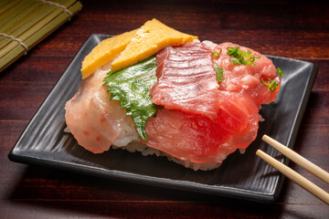 Japanese donburi rice bowl with tuna meat, omelet and leaf on plate, traditional Asian food