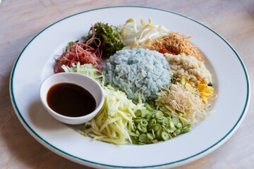 Spicy rice salad with vegetable. Thai southern spicy rice vegetable with dressing on white plate, Thai local food.