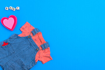 Different children's clothing, T-shirt and overalls. Space for text.