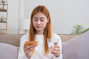 A young woman with a birth control pills reads instructions on how to use them correctly.