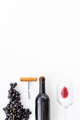 Red wine in the bottle with bunch of grapes and glass, top view