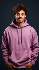 Fototapeta premium Portrait of a cheerful young male with curly hair wearing a trendy purple hoodie with a friendly smile