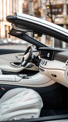 The convertible car's interior is highlighted in this image, with a focus on the luxurious white leather seats and sophisticated dashboard. The open top adds to the allure of freedom and elegance.