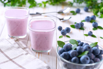 fresh natural homemade fruit yogurt in a glass jars with fresh blueberries on a light background, selective focus
