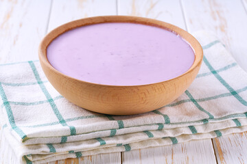 fruit yogurt in a wooden bowl on a light background, selective focus.