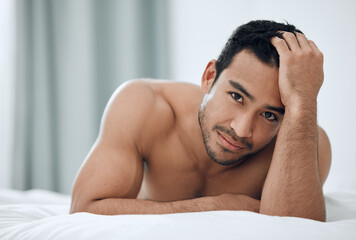 Morning, portrait and man lying in bed with confidence for relax, wellness and wakeup in bedroom....