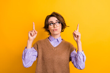 Portrait of minded puzzled woman wear knit waistcoat in glasses indicating look at promo empty...