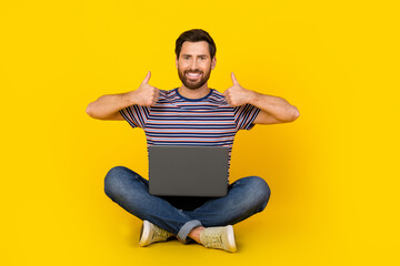 Photo of young modern guy with laptop likes symbol thumbs up enjoy using online service for shopping ecommerce isolated on yellow color background
