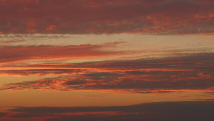 Fototapeta premium Intense dramatic panoramic sunset. Abstract different shades clouds at sunset sky background. Timelapse.