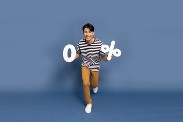 Happy Asian man running and showing 0% number or zero percent isolated over blue background, Full...