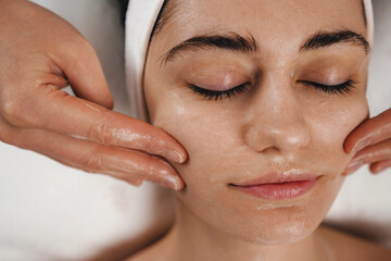 A woman is receiving a relaxing facial massage at a spa