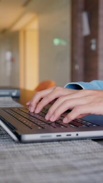 Vertical view of woman type on the laptop computer