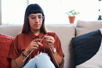 Creative, knitting and woman with wool in home for stitching project on sofa with needles. Craft,...