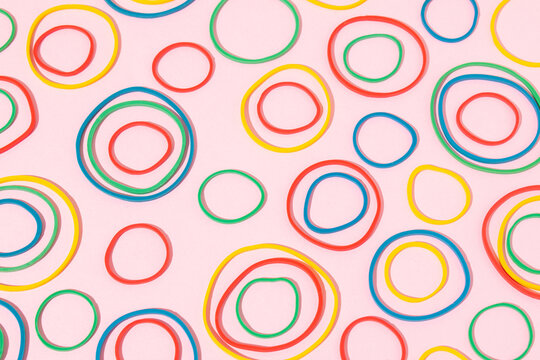 Colourful rubber bands on bright pink background. Minimal concept. Seamless pattern.