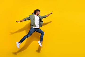 Portrait photo of young funny mexican guy in khaki shirt and jeans jumping running motivated...