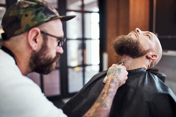 Beard, shave and man in barbershop with machine, client and tools for trendy facial cut at small...