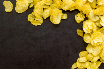 Snack background with crispy potato chips, top view