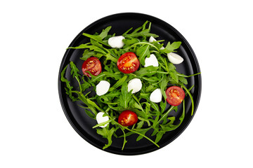 Arugula tomatoes and mozzarella salad on a black plate closeup isolated on white
