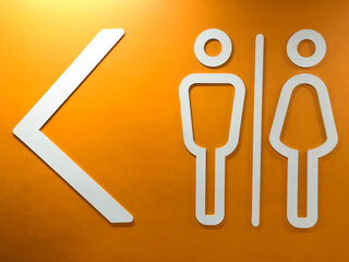 Men and women signs for restroom on yellow modern stone wall background. Toilet sign concept.