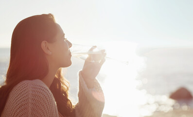 Relax, wine and woman at beach with glass, sunset and holiday in nature with water, sunshine and adventure. Ocean, summer vacation and girl thinking with champagne drink, peace and calm weekend trip