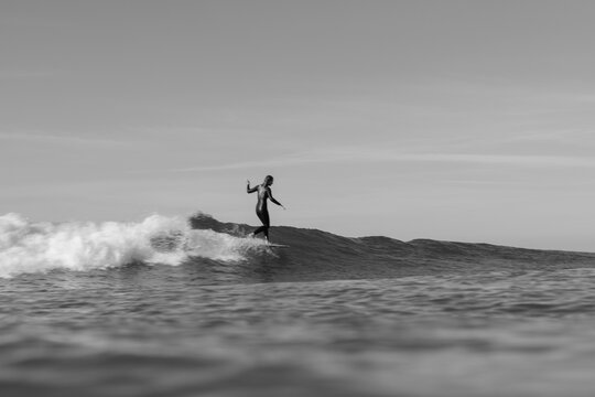 Fototapeta black and white photo of woman surfing on a wave