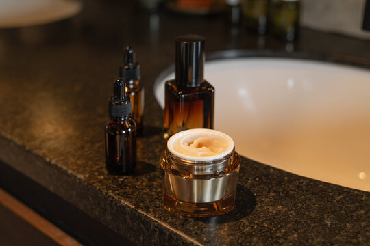 Amber bottles and jar with beauty care products in the bathroom