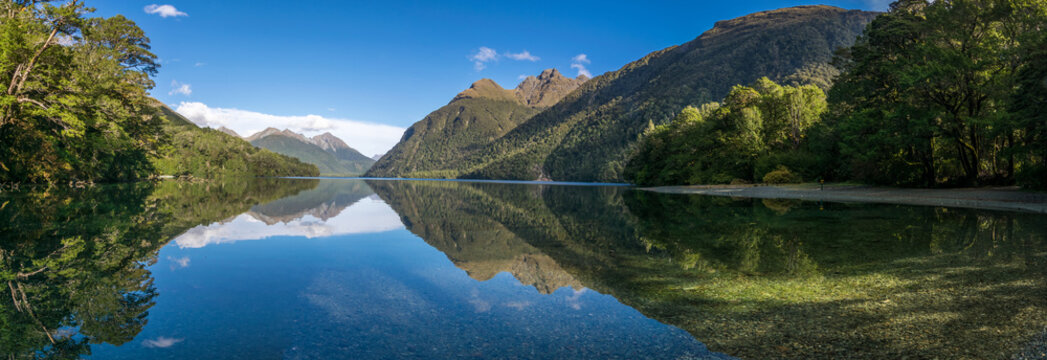 Panorama of mountains and rainforest reflections in a lake