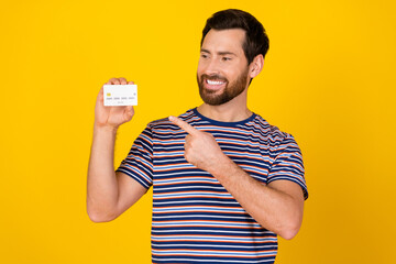 Photo of positive nice man with beard dressed striped t-shirt indicating look at credit card...