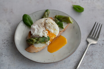 Toast bruschetta with grilled asparagus, poached egg and fresh cream cheese. Sourdough bread with vegetables and egg. Food photography. Healthy breakfast, brunch.