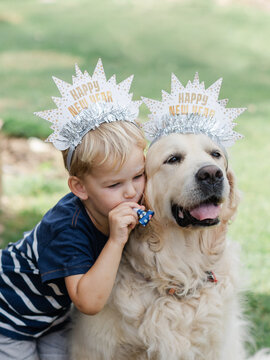 Young boy and dog in party hats