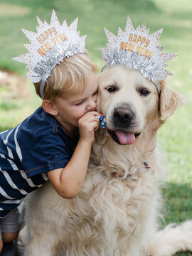 Young boy and dog in party hats