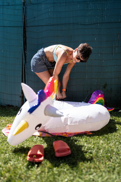 Woman inflating an unicorn pool float.