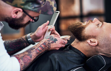 Beard, client and man in barbershop with shave, cut and tools for trendy facial hair care at small...