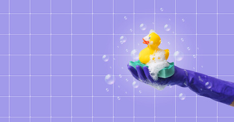 Female hand holding a soapy sponge and a rubber duck