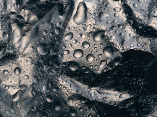 abstract background, texture. water surface. close up of water drops on the black surface.