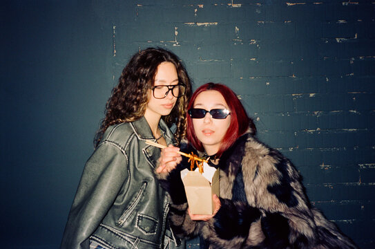 Two girlfriends eating Chinese food and have fun