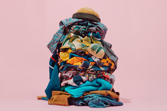 stack of clothes topped with a brown cap