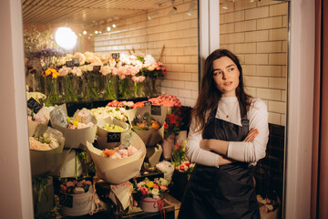 Woman florist at her own floral shop taking care of flowers