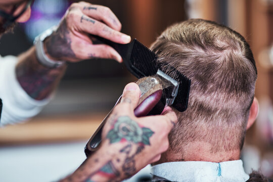 Barber shop, hands and men with haircut and customer with hairstylist and hair shaver with service. Grooming, equipment and buzz cut in salon with professional and expert with tattoo and comb