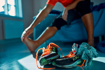 Man taking off dirty shoes at home after workout