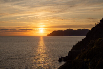 Fototapeta premium sunset over the sea with mountain in the background in cinque-terre italy