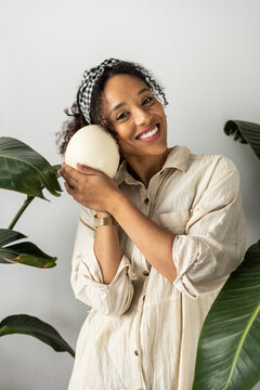 Casual woman studio portrait with ostrich egg