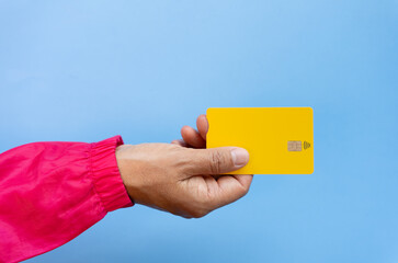 Close up of hand with yellow card seen from above on blue background