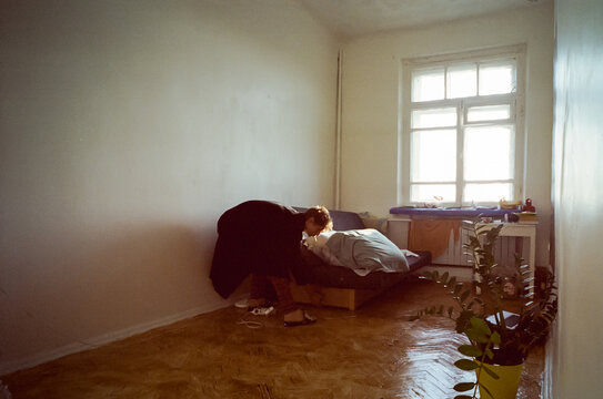 Artist student in his room deploying unfolding the bed sofa 