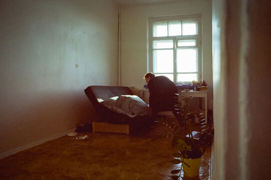 Artist student in his room deploying unfolding the bed sofa 