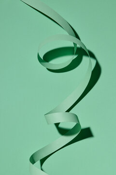 green curly ribbon isolated on green background.