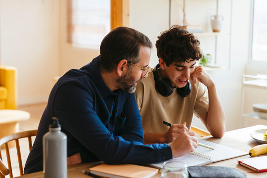Father and son doing homework at home